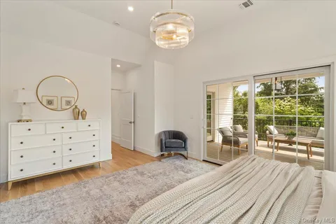a bedroom with a bed and large windows