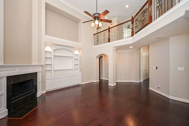 wooden floor in an empty room with a fireplace and a window