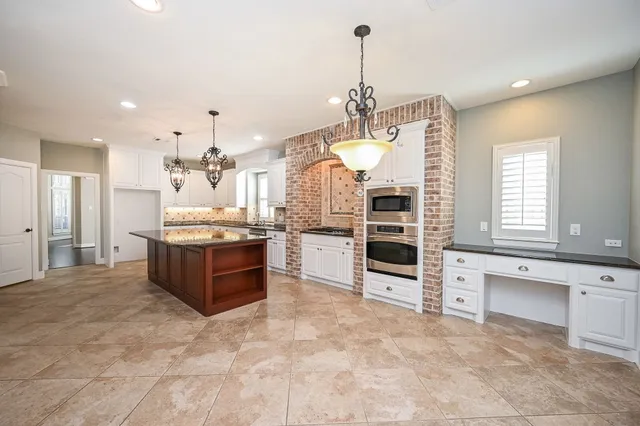 a large kitchen with kitchen island a large counter space appliances and cabinets