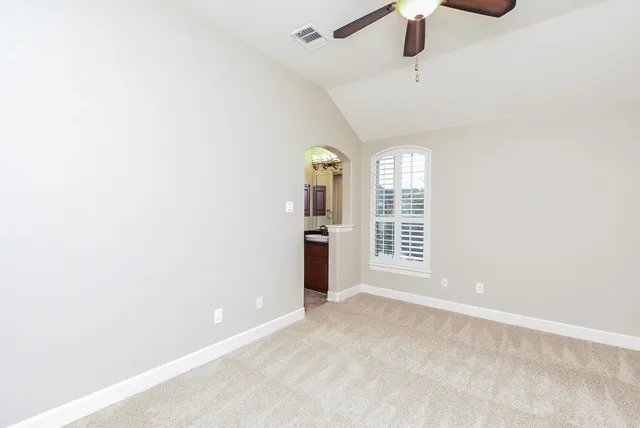 a view of a big room with windows and chandelier fan