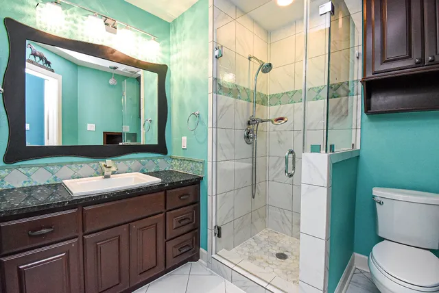 a bathroom with a sink a toilet and shower