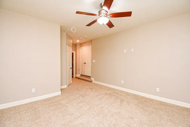 en empty room with windows and fan