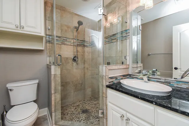 a bathroom with a sink toilet double vanity and shower