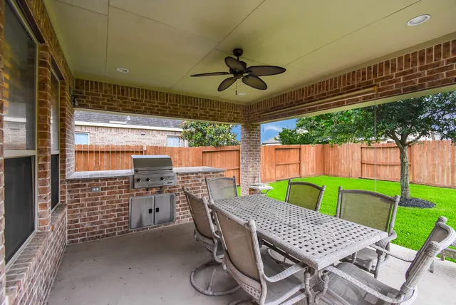 a view of a patio with a table chairs and a backyard