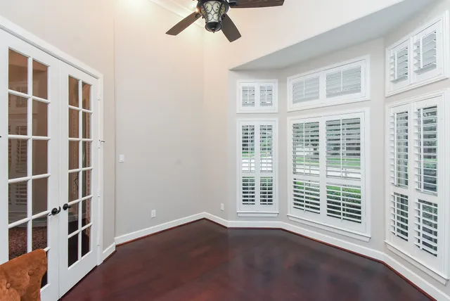 a view of an empty room with a window and wooden floor