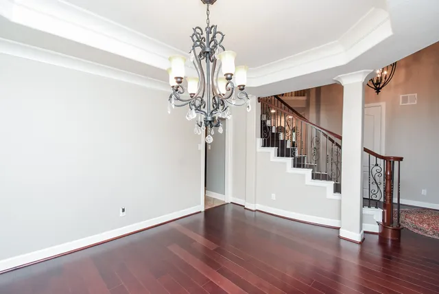 a view of a hallway with wooden floor and staircase