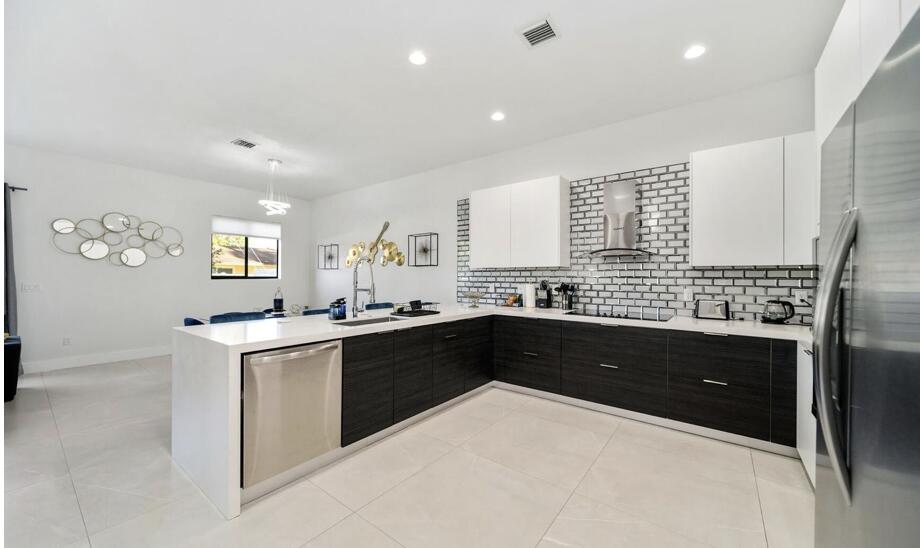 3254 Southwest 44th Street Fort Lauderdale, FL 33312 - Photo 10 of 26 a kitchen with stainless steel appliances kitchen island granite countertop a refrigerator and a stove top oven