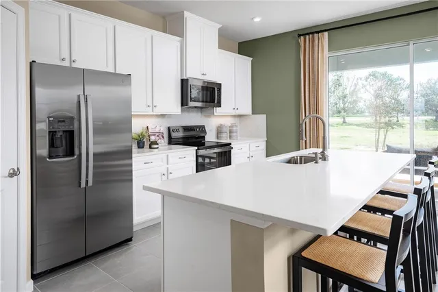 a kitchen with stainless steel appliances a refrigerator sink and stove