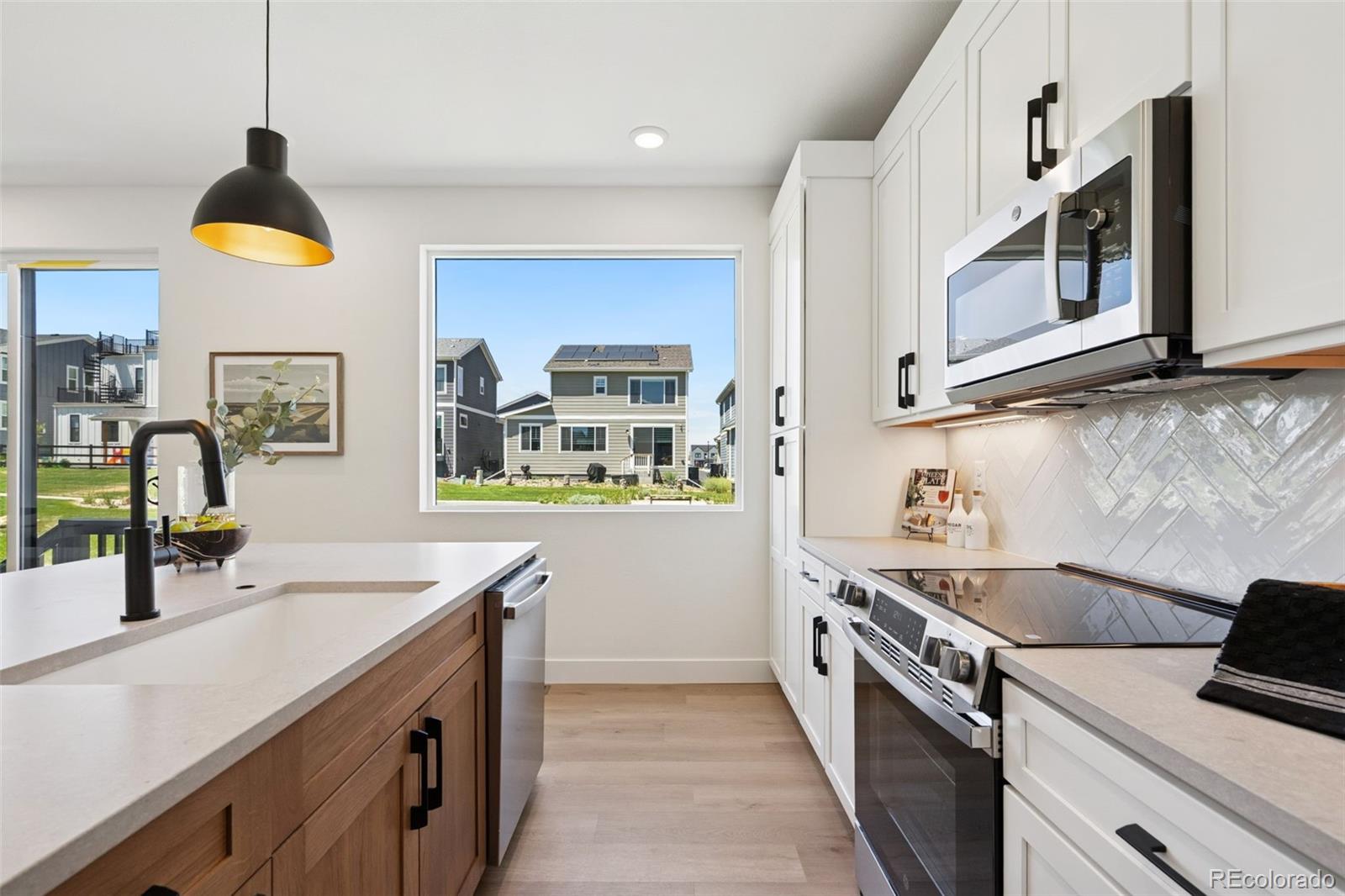113 Mohawk Circle Superior, CO 80027 - Photo 14 of 50 a kitchen with stainless steel appliances a sink a stove and a wooden floor