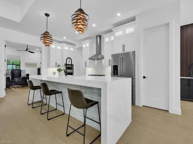 a kitchen with kitchen island stainless steel appliances a dining table and chairs