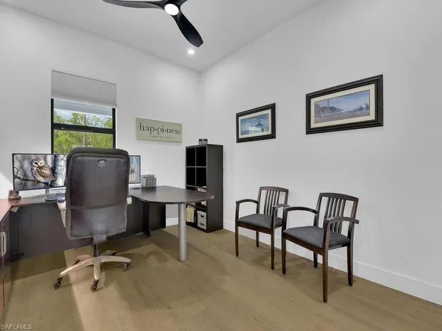 a view of a workspace with furniture and a window