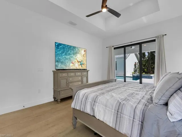 a bedroom with a bed window and a flat tv screen