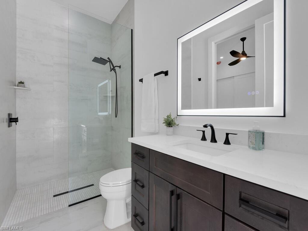 3475 3rd Avenue Southwest Naples, FL 34117 - Photo 24 of 49 a bathroom with a granite countertop sink a toilet and shower