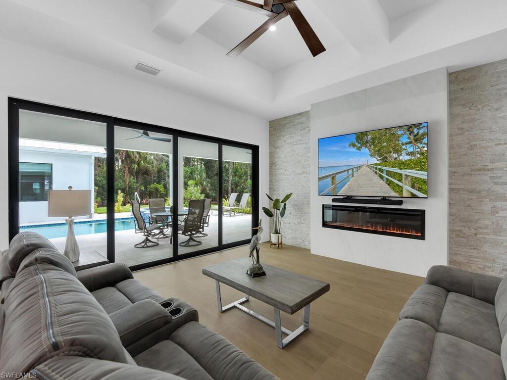 3475 3rd Avenue Southwest Naples, FL 34117 - Photo 10 of 49 a living room with furniture floor to ceiling window and a flat screen tv