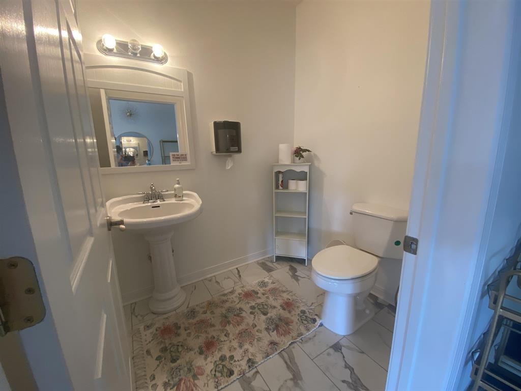 55 Old South Road Counce, TN 38326 - Photo 11 of 24 a white toilet sitting next to a bathroom sink and a mirror