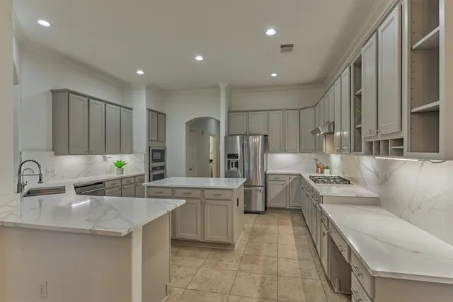 a large kitchen with stainless steel appliances lots of counter space and a sink