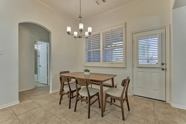 a view of a dining room with furniture and chandelier