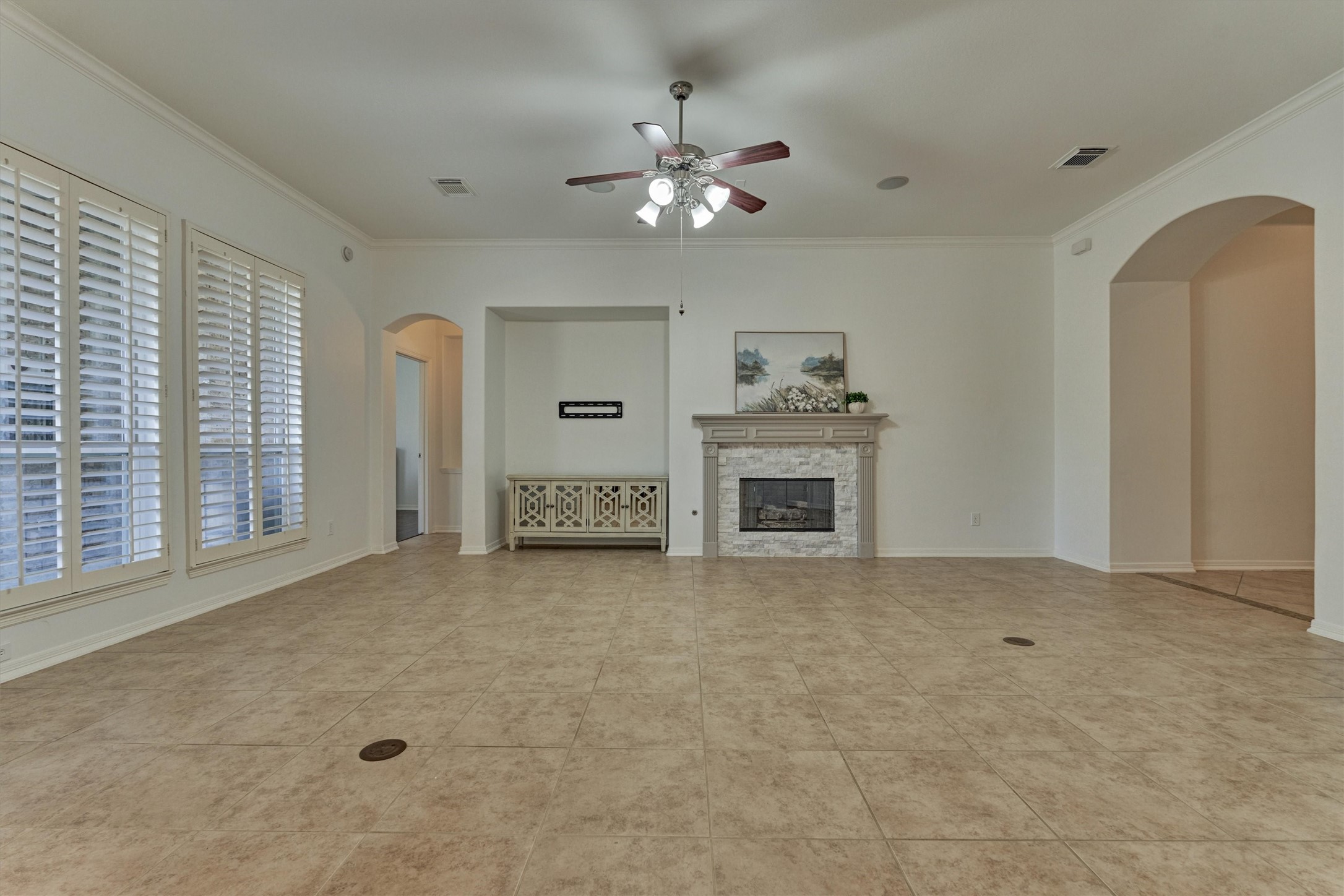 94 Oriel Oaks Circle The Woodlands, TX 77382 - Photo 24 of 46 a view of a livingroom with a ceiling fan a kitchen space and a fireplace