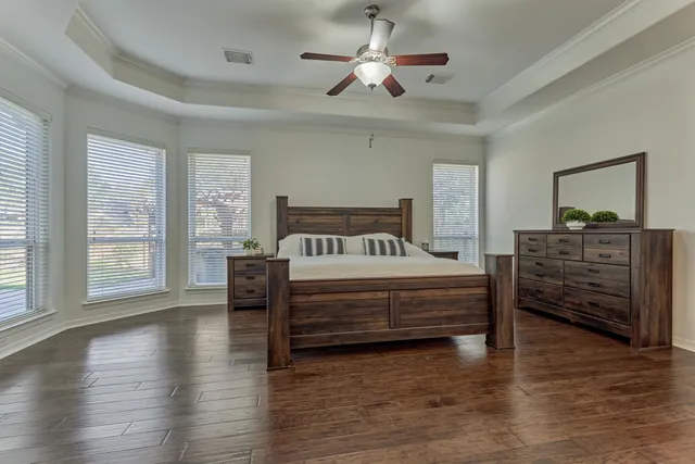 a spacious bedroom with a bed and a dresser