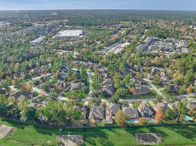 an aerial view of residential houses with outdoor space and trees