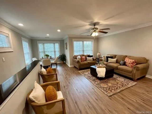 a living room with furniture ceiling fan and a wooden floor