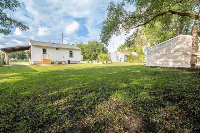 a view of a big house with a big yard and large trees