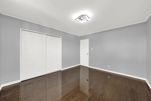 a view of a big room with wooden floor and windows