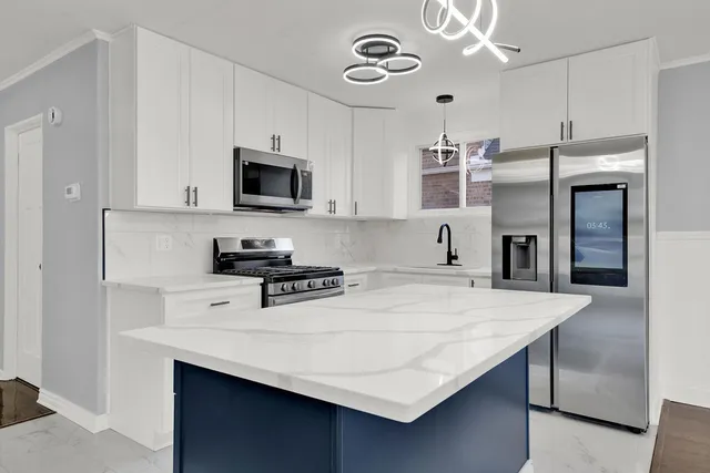 a kitchen with stainless steel appliances a stove refrigerator sink and microwave