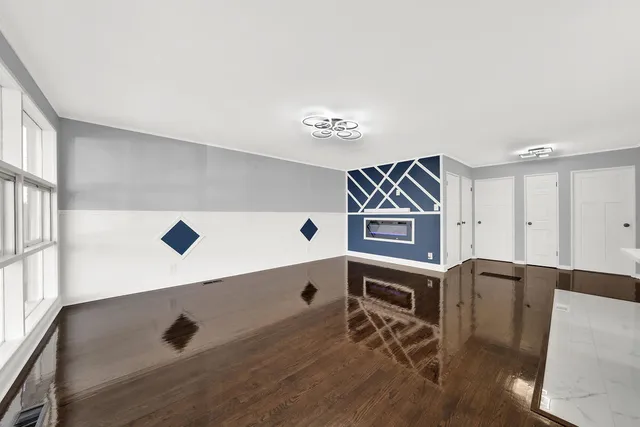 a view of kitchen with stainless steel appliances wooden floor and chair