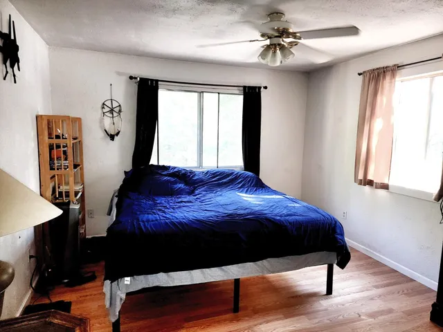 a bedroom with a bed dresser and window