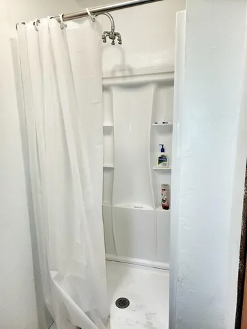 a bedroom with a bed dresser and a large window