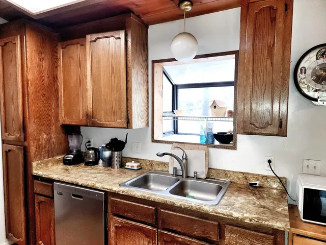 a kitchen with granite countertop a sink a stove and cabinets