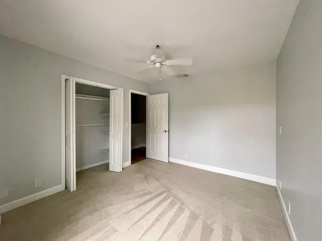 a view of an empty room with a ceiling fan