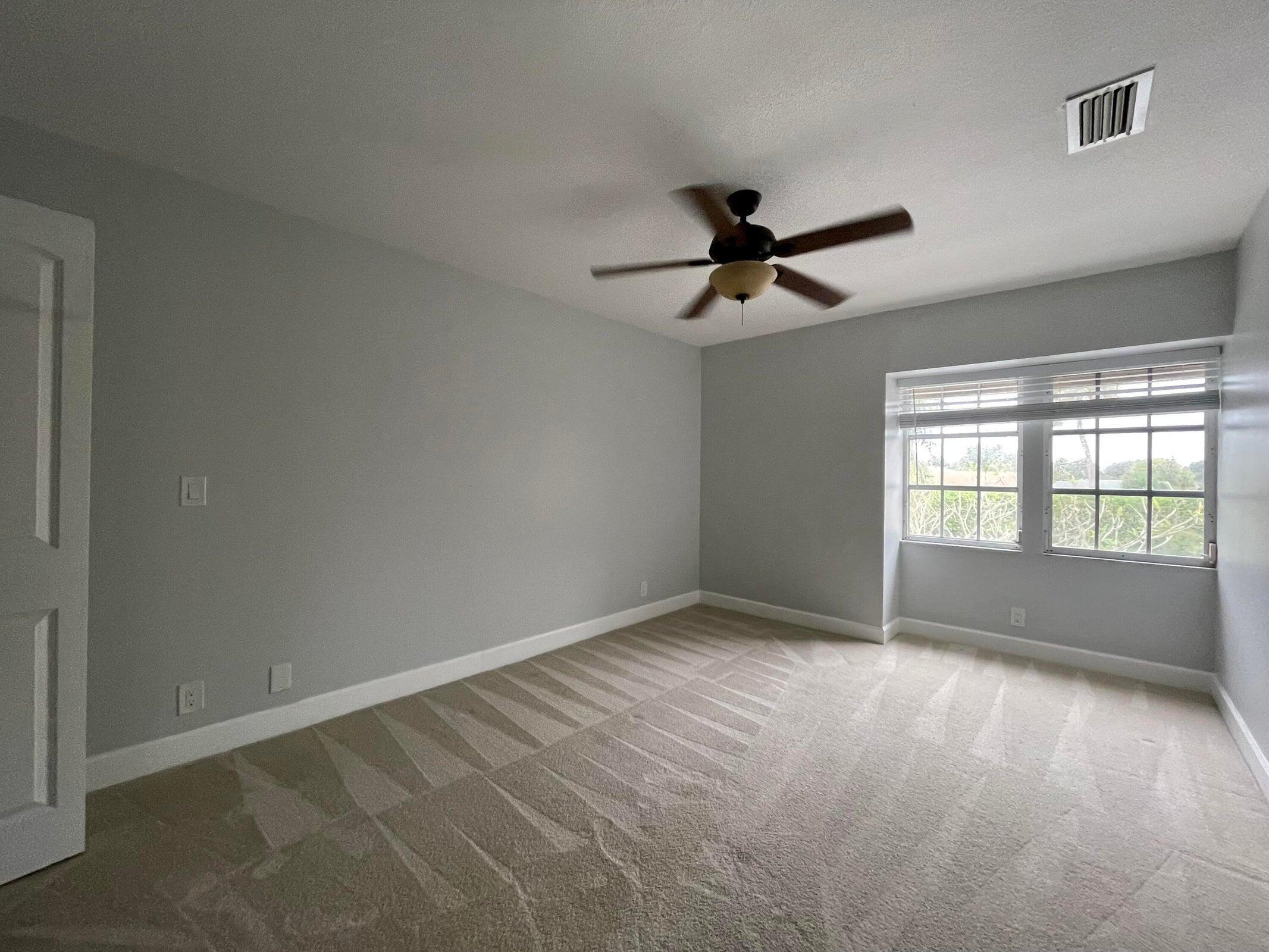 11551 Winchester Drive Palm Beach Gardens, FL 33410 - Photo 20 of 22 wooden floor in an empty room with a window