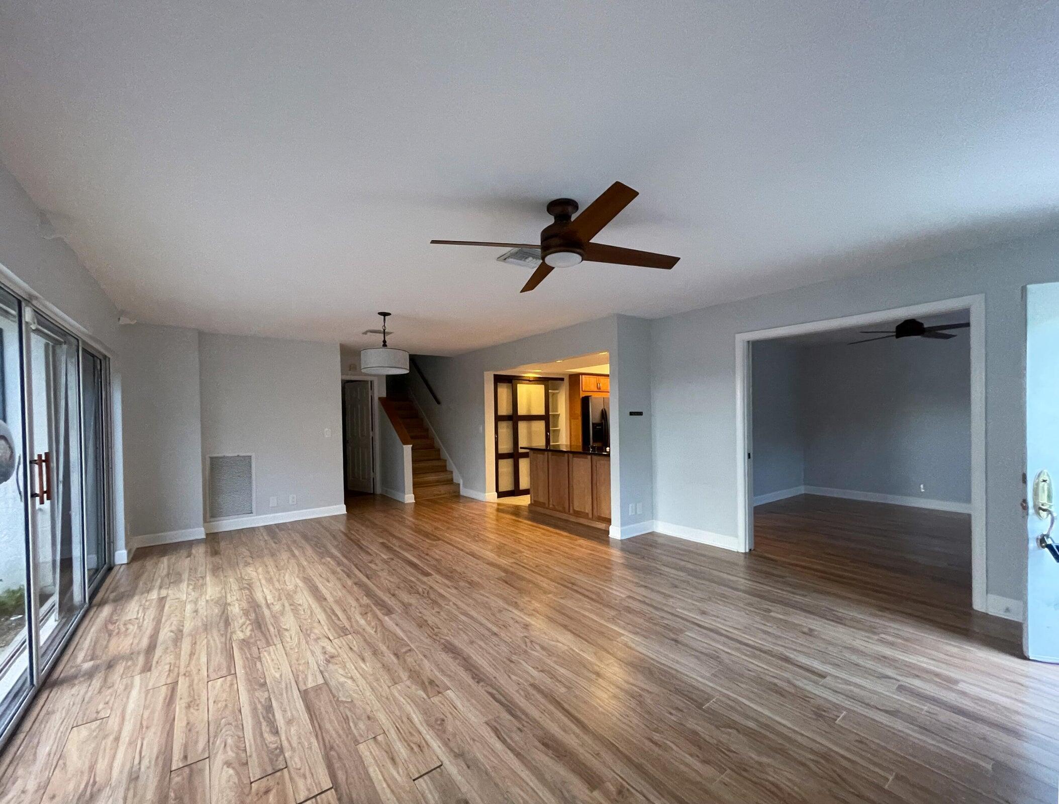 11551 Winchester Drive Palm Beach Gardens, FL 33410 - Photo 4 of 22 a view of empty room with wooden floor and ceiling fan