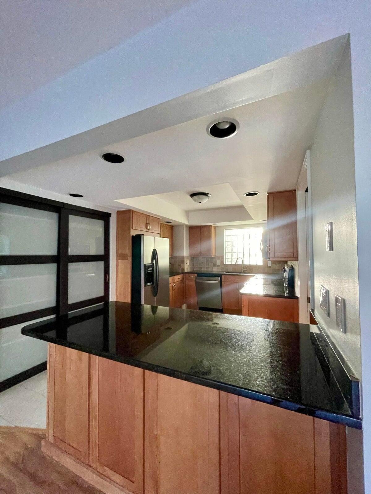 11551 Winchester Drive Palm Beach Gardens, FL 33410 - Photo 8 of 22 a large kitchen with kitchen island a counter space a sink a window and stainless steel appliances