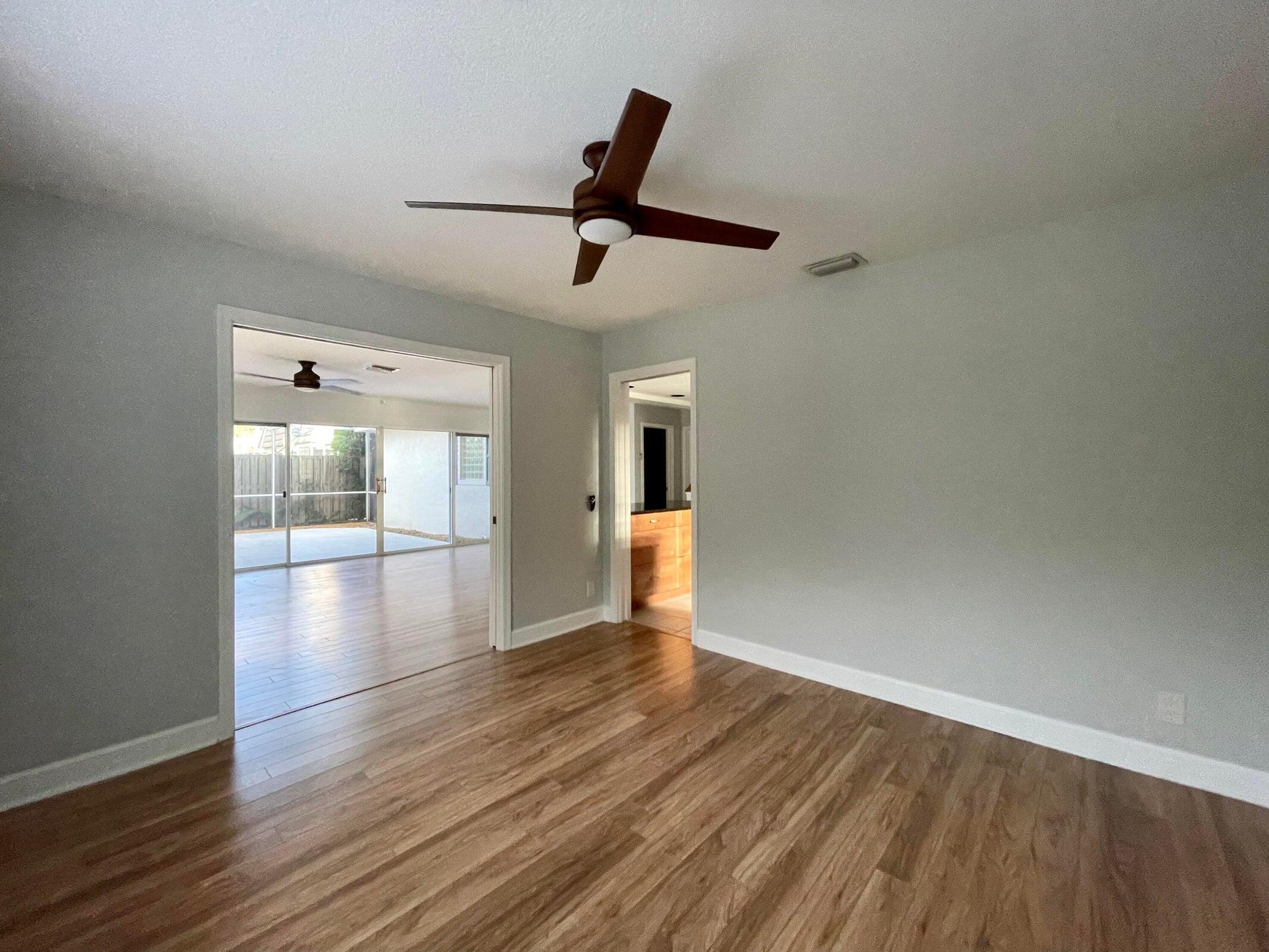11551 Winchester Drive Palm Beach Gardens, FL 33410 - Photo 10 of 22 a view of empty room with wooden floor and fan