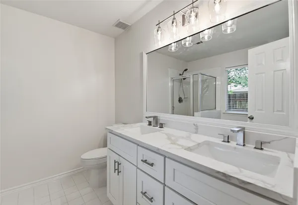a bathroom with a granite countertop sink a toilet and a mirror