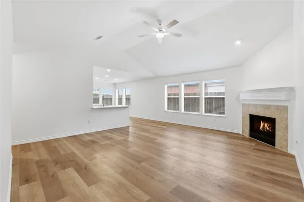 a view of an empty room with a fireplace and a window