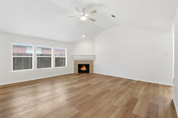 a view of an empty room with a fireplace and a window