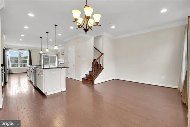 a view of a room with wooden floor and chandelier