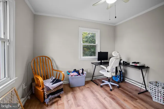 a view of a workspace with furniture and a window