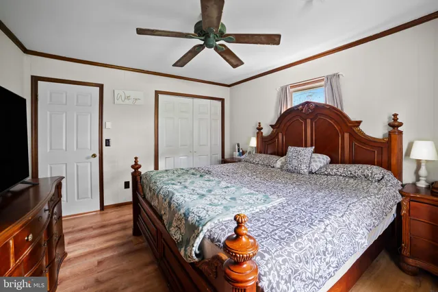 a bedroom with a bed and dresser with mirror