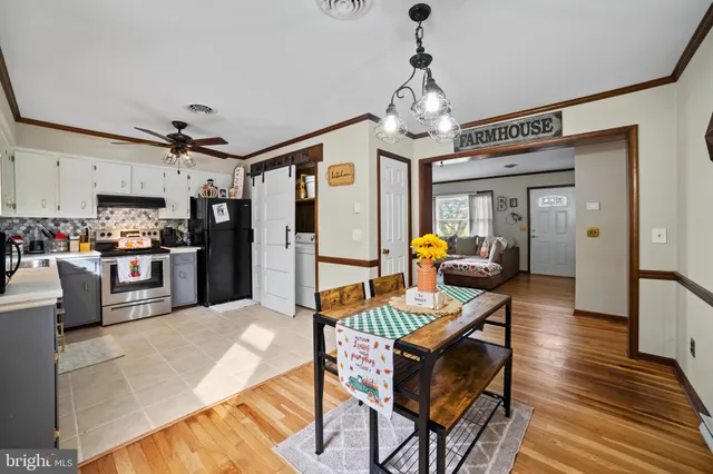 a view of a dining room with furniture a chandelier and wooden floor