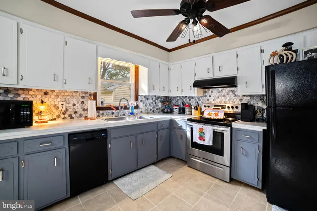 a kitchen with kitchen island granite countertop stainless steel appliances a sink window and cabinets