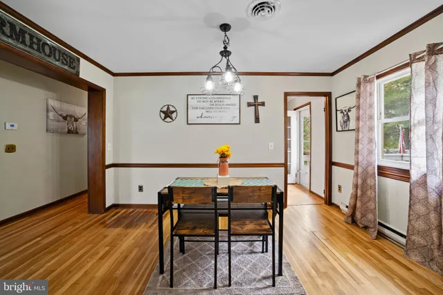 a view of a dining room with furniture wooden floor and a chandelier
