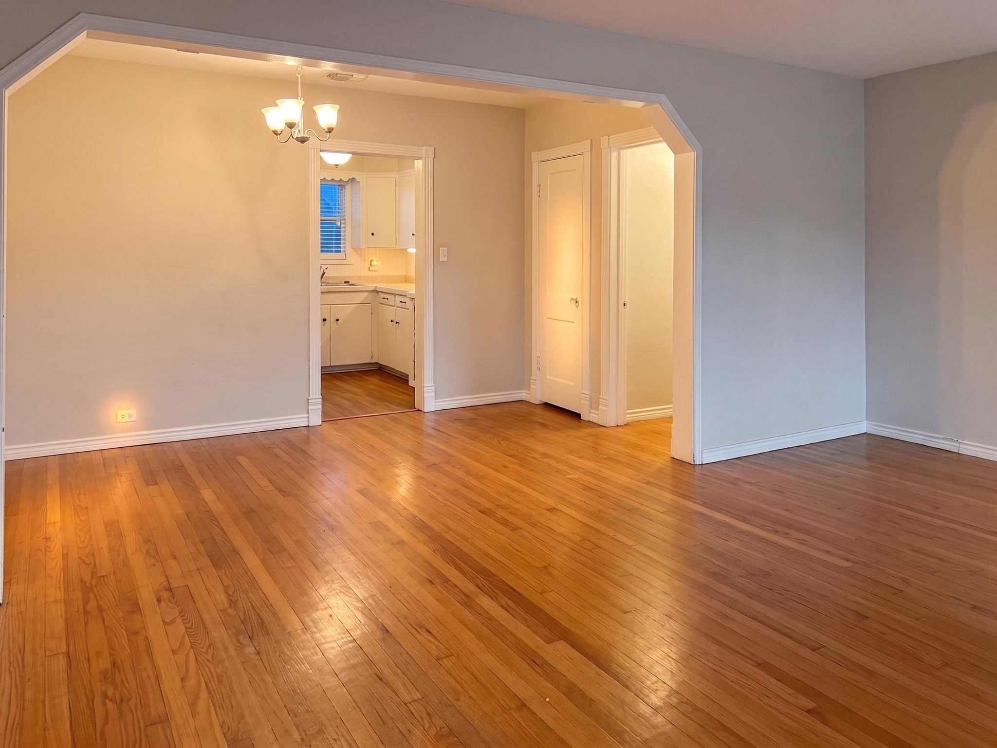 2313 Avenue L Rosenberg, TX 77471 - Photo 6 of 31 Spacious living room featuring beautiful hardwood floors, an open layout, and a wide arched entry leading to the dining room.