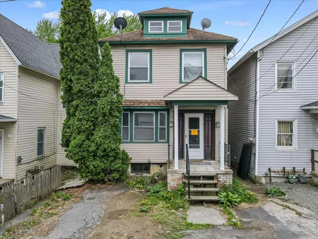 a front view of a house with a garden