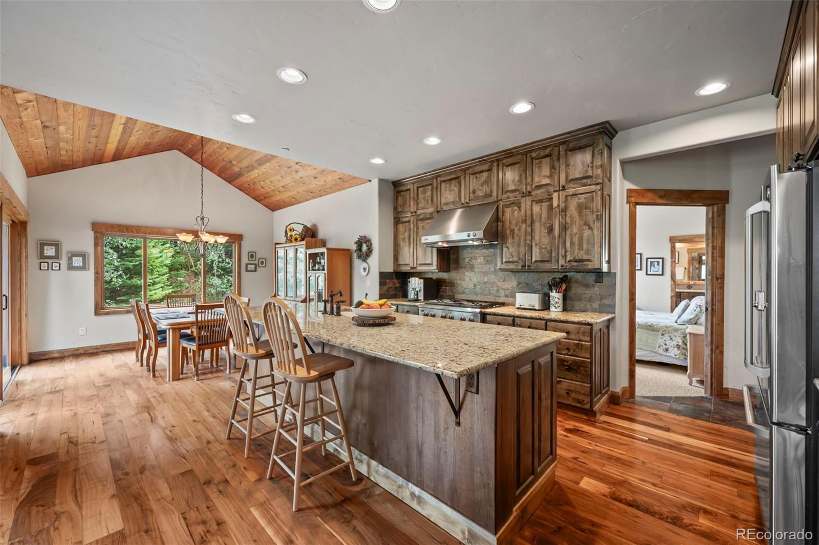 560 Two Cabins Drive Silverthorne, CO 80498 - Photo 5 of 49 a kitchen with a table chairs stove and refrigerator
