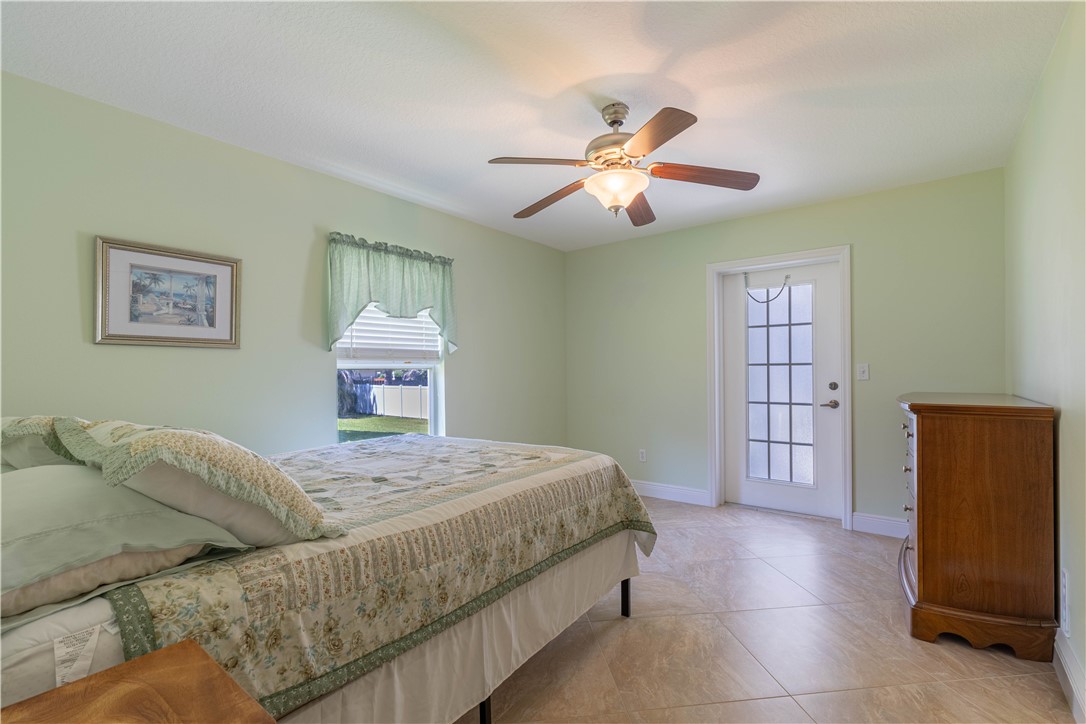 414 Ash Street Sebastian, FL 32958 - Photo 23 of 36 a bedroom with a large bed and a chandelier